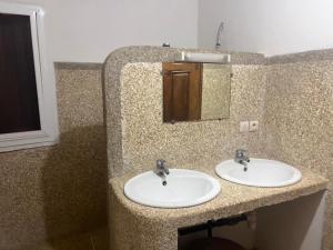 a bathroom with two sinks and a mirror at Villa Farou in Mbour +8 photos