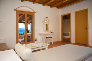 a bedroom with a bed and a view of the ocean at Pambelos Lodge - Apartments in Koufonisia