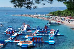 a group of inflatable water slides in the water at a beach at Holiday house with a parking space Bol - Brac - 2894 in Bol +14 photos
