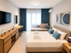 a hotel room with a large bed and a couch at Aura di centro Thassos in Limenas