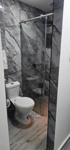 a bathroom with a toilet and a glass shower at Balcones de las lajas in Cali