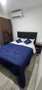a bedroom with a blue and white bed with blue pillows at Balcones de las lajas in Cali