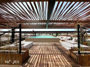 a pavilion with beds and a swimming pool at Amelia By Waves in Tulum