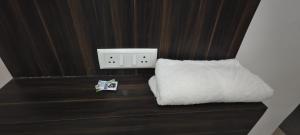 a couch with a white pillow and a lightswitch at La Buddha Villagers BY Ansh Palace Hotel in Agra