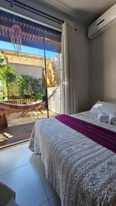 a bedroom with a bed and a large window at Casa da Flor Guest House – Praia Grande – Beto Carrero in Penha