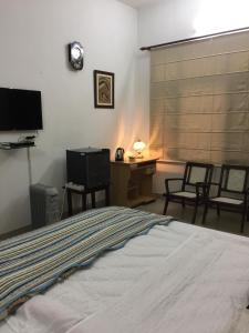 a bedroom with a bed and a desk and a television at Luxurious Homestay- Chandīgarh in Chandīgarh