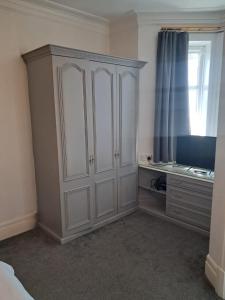 a bedroom with a large white cabinet and a window at The Rising Sun in Rogerstone