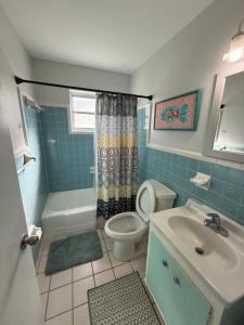 a bathroom with a toilet and a sink and a shower at Rosewood 1 in Vero Beach +8 photos