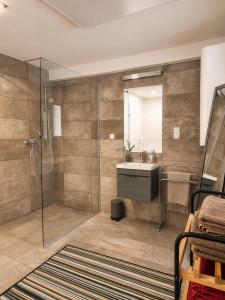 a bathroom with a glass shower and a sink at Geigenhof in Neudorf bei Ilz +13 photos