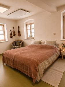 a bedroom with a large bed and a chair at Geigenhof in Neudorf bei Ilz