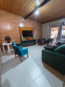 ein Wohnzimmer mit Sofa und Fernseher in der Unterkunft Mar e lar e lazer in Pinheira