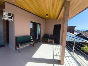 eine Terrasse mit zwei Bänken auf einem Balkon in der Unterkunft Mar e lar e lazer in Pinheira