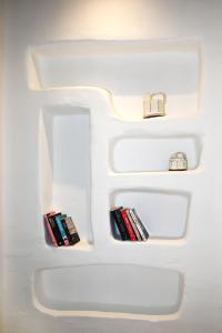 a white refrigerator with three shelves with books at Pambelos Lodge - Apartments in Koufonisia