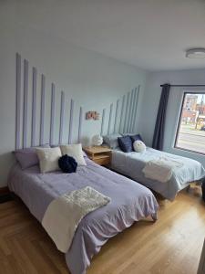 a bedroom with two beds and a window at Martin's apartment in Saguenay