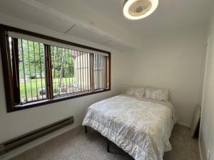 a bedroom with a bed and a large window at Anchorage Fireoved Home Theater Experience in Anchorage