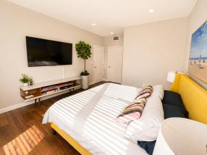 a bedroom with a bed and a tv on a wall at Spacious, Comfortable, and Central Condo in Los Angeles