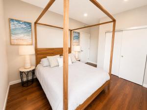 a bedroom with a four poster bed with white sheets at Spacious, Comfortable, and Central Condo in Los Angeles