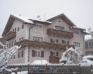 a building with a sign on it in the snow at Hotel Nès Crépes in Pozza di Fassa