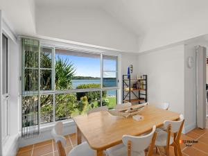 a dining room with a table and a large window at Riverview Apartment 1.4 in Iluka