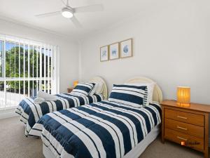 a bedroom with two beds and a window at Riverview Apartment 1.4 in Iluka