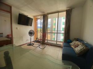 a living room with a blue couch and a large window at Apartamento en Melgar con la mejor ubicacion in Melgar