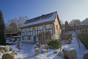 une maison avec de la neige devant elle dans l'établissement Goldbachhäuschen, à Olbersdorf