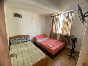 a small bedroom with two beds and a window at Apartamento en Melgar con la mejor ubicacion in Melgar +5 photos