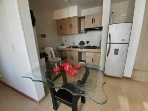 a kitchen with a glass table and a refrigerator at Apartamento en Melgar con la mejor ubicacion in Melgar