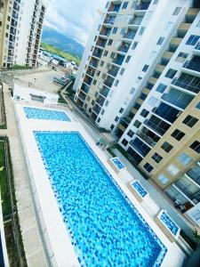 an overhead view of two swimming pools in front of tall buildings at Apartamento en Melgar con la mejor ubicacion in Melgar