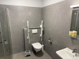 a bathroom with a toilet and a sink at Tjarna Hotel in Keflavík