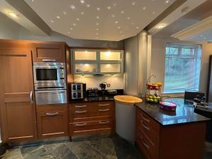 a kitchen with wooden cabinets and a counter top at The Cairn in Airdrie