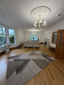a large living room with a couch and a chandelier at The Cairn in Airdrie