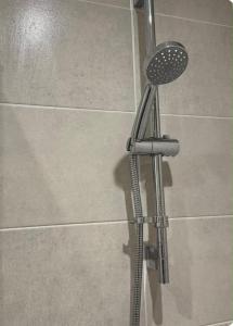 a shower in a bathroom with a shower head at Elegant King Room with Wifi & Parking in Milton Keynes