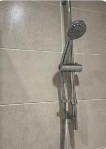 a shower in a bathroom with a shower head at Elegant King Room with Wifi & Parking in Milton Keynes