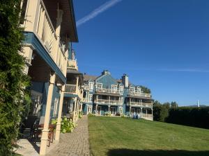 a large house with a lawn in front of it at La Remontée Appartements Hôtel in La Malbaie