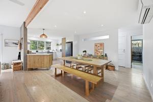 a kitchen and dining room with a wooden table and bench at Tamara Coastal Retreat in Inverloch