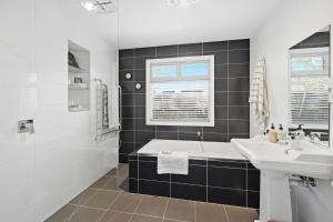 a bathroom with a sink and a bath tub and a sink at Tamara Coastal Retreat in Inverloch +21 photos