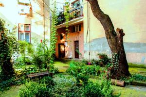 a garden in front of a building with a tree at City Oasis Apartment in Belgrade