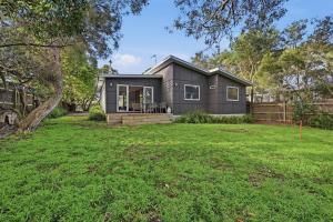 a small black house with a yard at Tamara Coastal Retreat in Inverloch