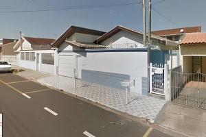 a house with a white gate and a parking lot at Tecnohouse próxima ao Sesc in Franca