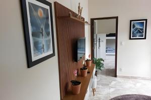 a hallway with potted plants on a wall and a mirror at Tecnohouse próxima ao Sesc in Franca