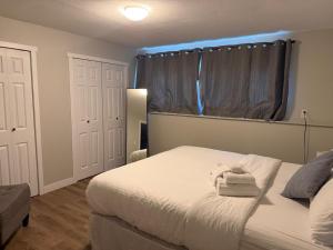 a bedroom with a bed with two towels on it at Supinder's Rentals in Golden