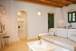 a living room with a white couch and a table at Pambelos Lodge - Apartments in Koufonisia +78 photos