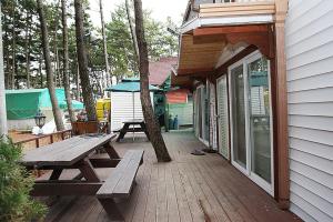 a wooden deck with a picnic table and a tent at Sarangiimeomuneunjip Pension in Taean +2 photos