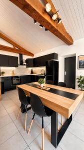a kitchen with a wooden table and black cabinets at Gite de charme avec jaccuzzi privé in Coëx