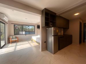 a kitchen with a refrigerator and a room with a bed at Torre OCEAN DRIVE in Montañita