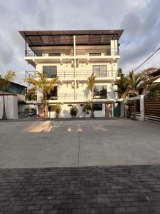 a white building with palm trees in front of it at Torre OCEAN DRIVE in Montañita