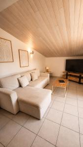 a living room with two couches and a flat screen tv at Gite de charme avec jaccuzzi privé in Coëx