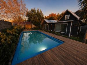 a swimming pool on a deck next to a house at Yucca Lodge en Colbún in Colbún