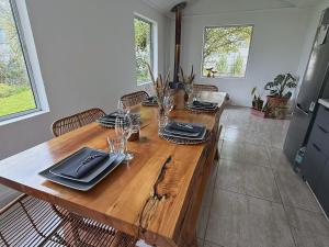 a wooden table with plates and wine glasses on it at Yucca Lodge en Colbún in Colbún
